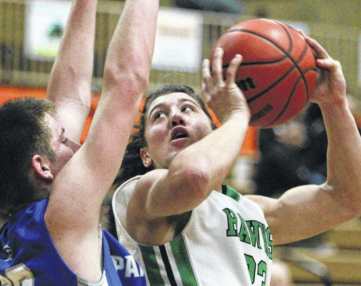 Carrollton’s Jerrett Smith (right), shown looking to shoot over a North Greene defender during action at the Beardstown Tourney on Jan. 27, and the Hawks ended their season Tuesday with a loss to the host Rockets in the Okawville Class 1A Sectional.