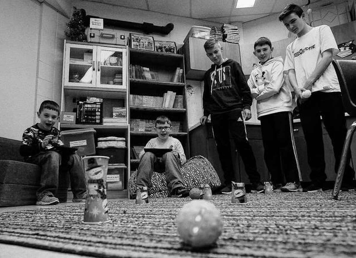 Second graders Urijah Burns (from left) and Eli Binkley play a remote controlled game with help from eighth graders Christian Schanefelt, Joey Young and Austin Cohn from Warrensburg-Latham Middle School at the elementary school in Warrensburg. The middle school students at Latham spend time playing games with elementary school students for their kindness project.