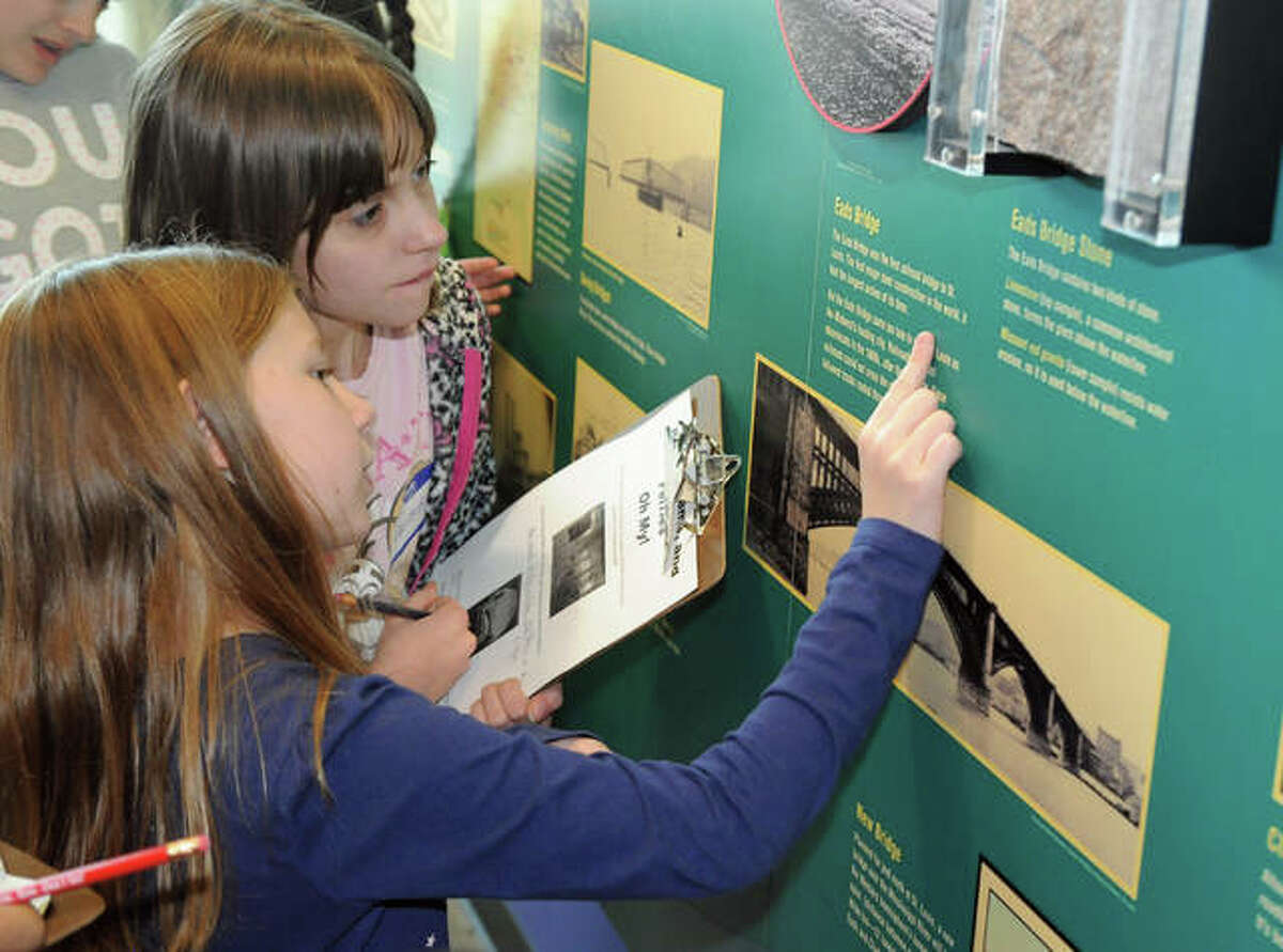 Girl Scouts identify bridges in the exhibits at the National Great Rivers Museum on Saturday during the Building Bridges Merit Badge session.