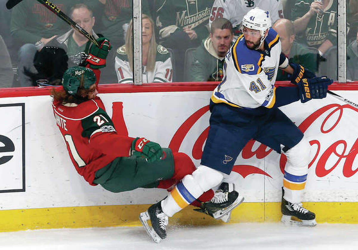 Minnesota’s Ryan White, left, is upended by the Blues’ Robert Bortuzzo in the second period Tuesday’s game in St. Paul, Minn.