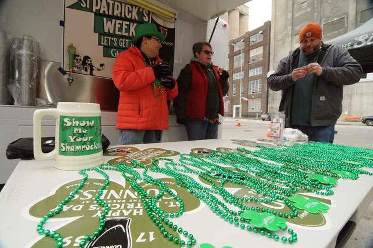 Mary Vankirk, left, owner of Morrison’s Irish Pub, tends the beer wagon with Cindy and Mike Larson during Saturday’s Downtown Alton St. Patrick’s Festival.