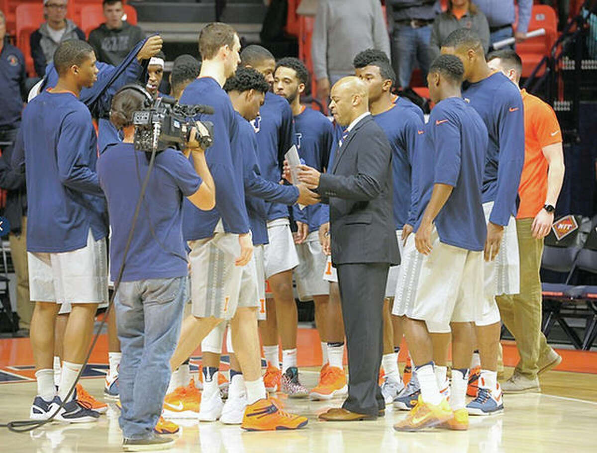 Interim Illinois basketball coach Jamall Walker, center, speaks with the team during Tuesday night’s NIT opener against Valparaiso at State Farm, Center in Champaign. Walker is a former assistant coach at Alton High sShool.