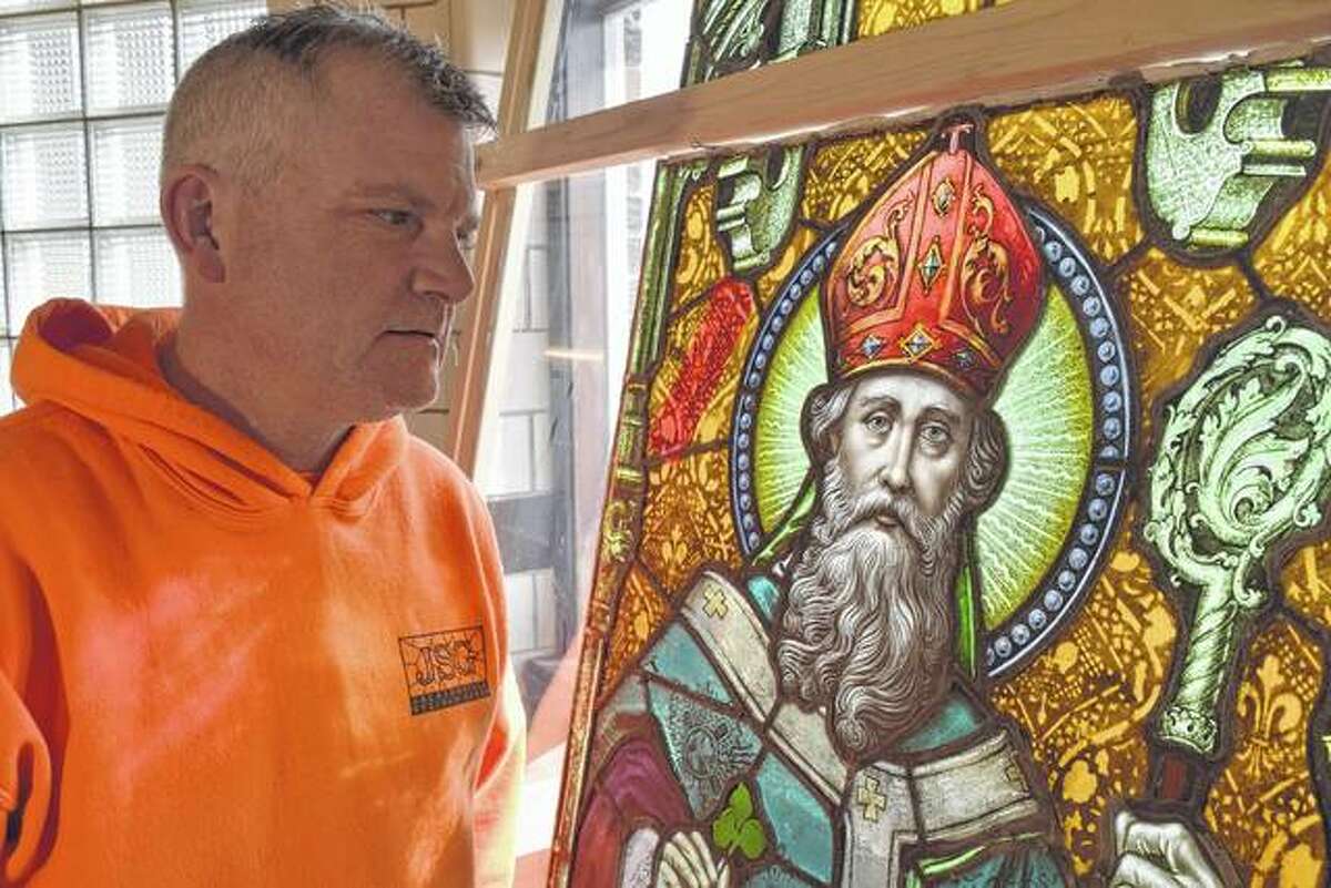 Ron Weaver, owner of Jacksonville Stained Glass, looks at a stained glass image of St. Patrick at the studio on East Morton Avenue. The image of St. Patrick is part of a window that Jacksonville Stained Glass artisans will soon restore and deliver to a Peoria customer.