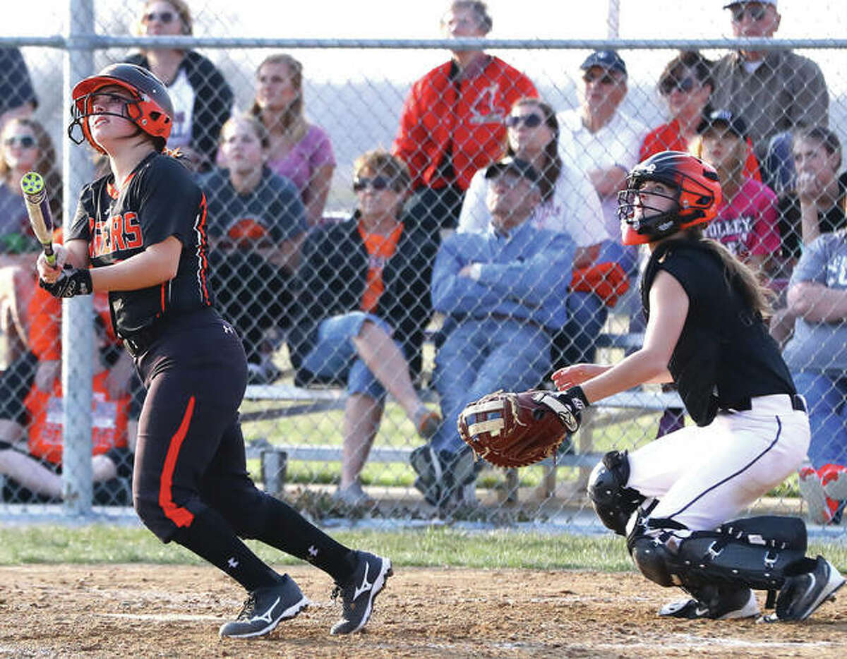 Edwardsville’s Taryn Brown (left) and Gillespie catcher Mackenzie Kasarda, along with fans seated on the bleachers, watches Brown’s three-run homer sail over the fence in left to tie the game at 8-8 om the sixth inning Monday at Gillespie. The Tigers went on to a 12-9 victory.