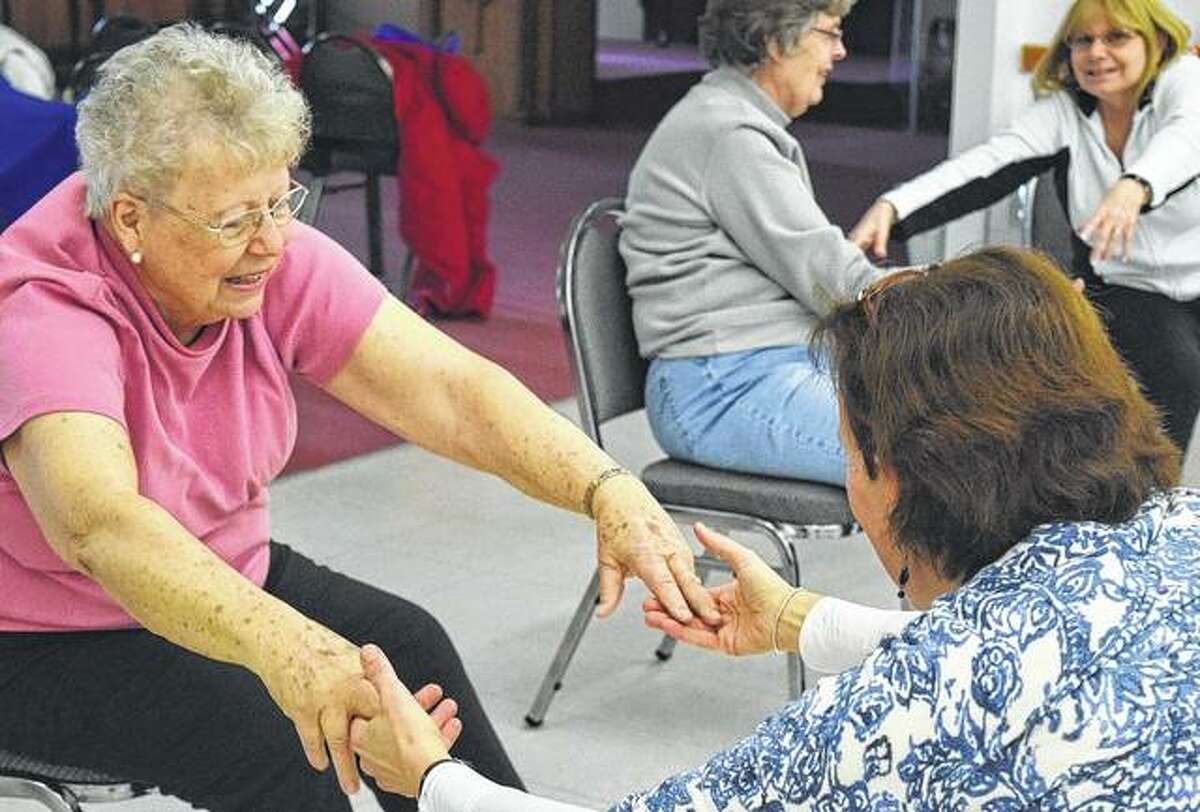 Darlene Sills (left) of Jacksonville warms up as a part of the Joy of Movement, Parkinson’s Dance and Exercise class with instructor Eve Fischberg.