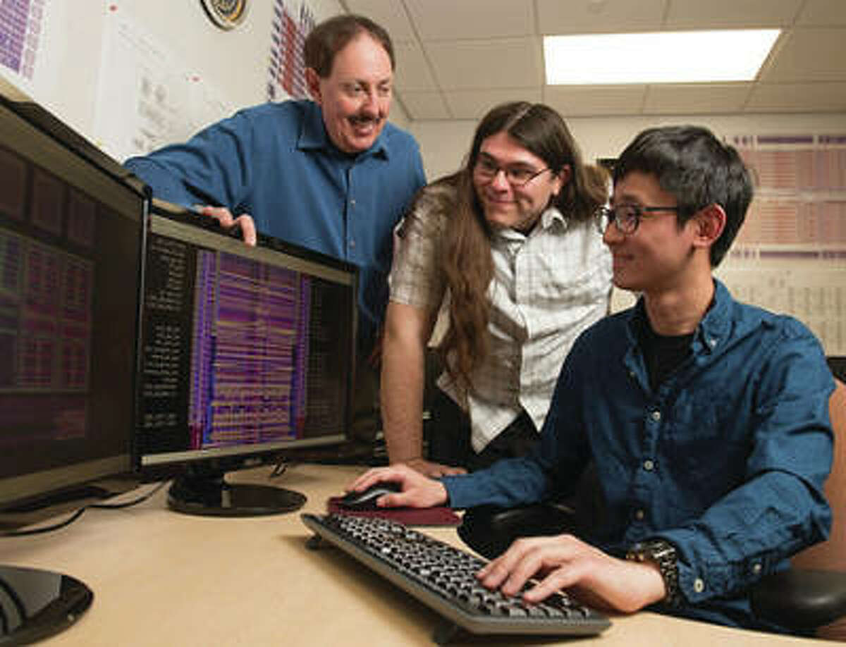 SIUE Graduate student Pohan Wang, of Taiwan, is seated in the research lab, with fellow student Bryan Orabutt, of Springfield, Illinois, middle, and Professor George Engel, left, looking on.