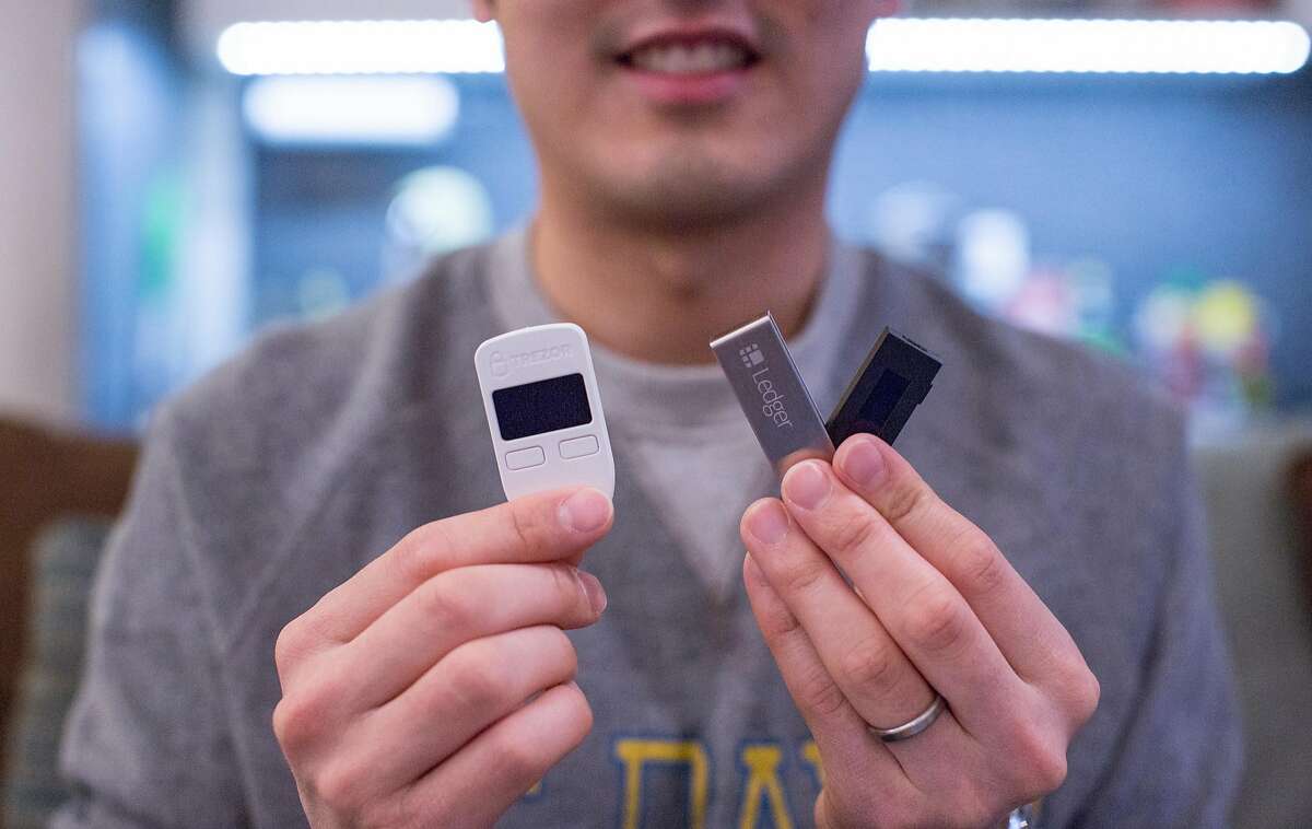 Chris Chuang holds up two of his hardware wallets to securely hold his cryptocurrency's like Bitcoin. Brian Feulner, Special to the Chronicle