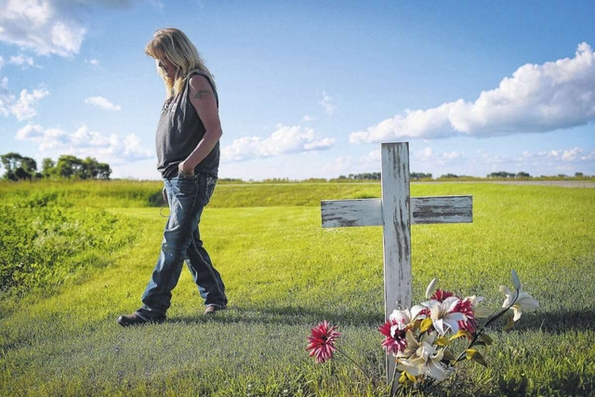 Renee Jones Schneider | Minneapolis Star Tribune (TNS) Gayle Lund walks by a cross she put in the spot on her driveway where her 24-year-old son Jake Fuglie died in a tractor rollover in 2010. He was driving his grandfather’s old tractor to plow snow and it tipped on the small incline of the grass by the driveway.