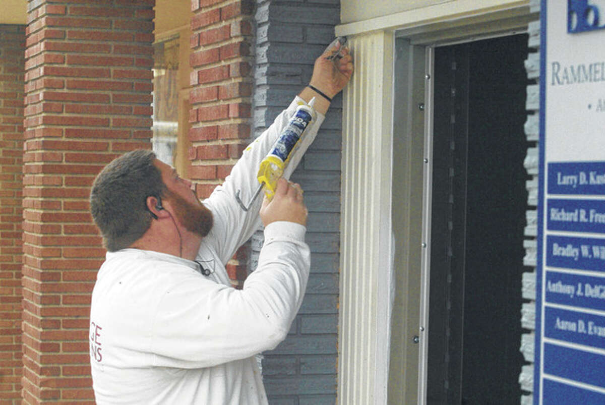 Paul Wellhausen of J.B. Large & Sons Painting repairs a door frame at the Rammelkamp Bradney Attorneys at Law office on West State Street.