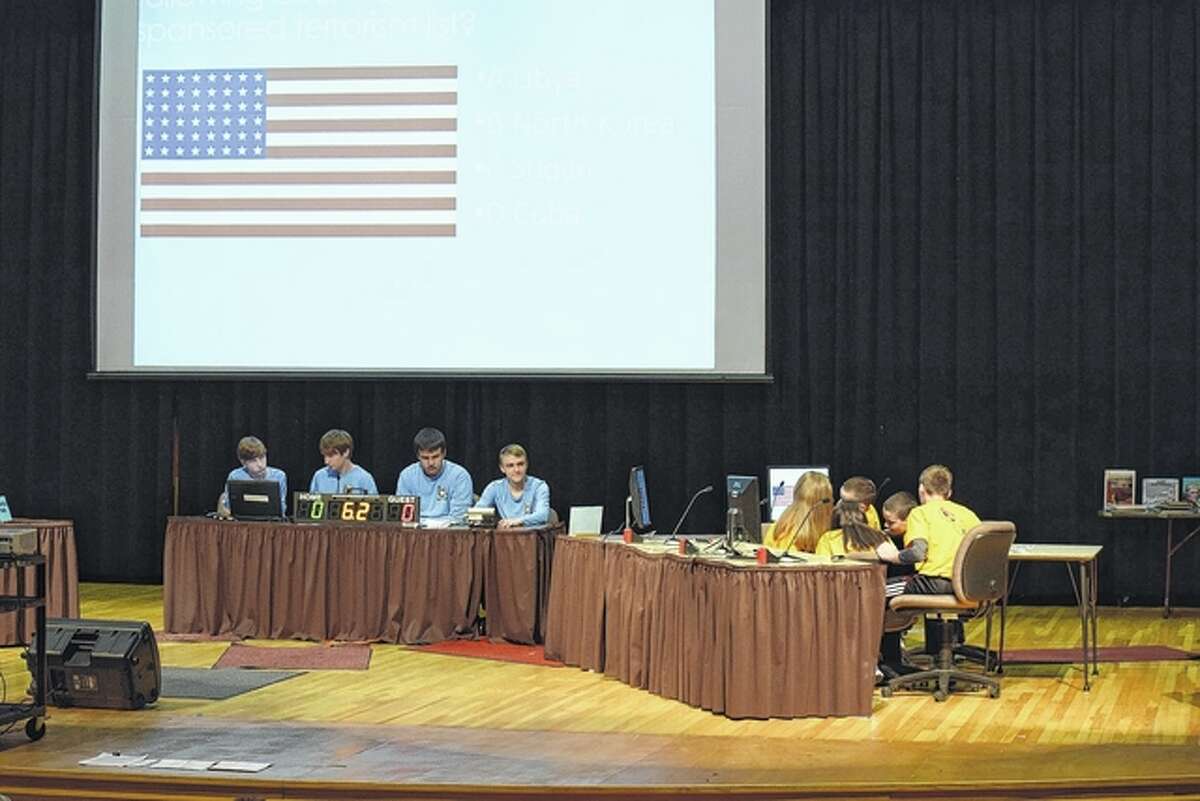 Members of the Eisenhower Elementary School gold team (right) discuss one of the first questions at the 23rd Regional Geography Bowl Wednesday night at the Jacksonville High School auditorium.