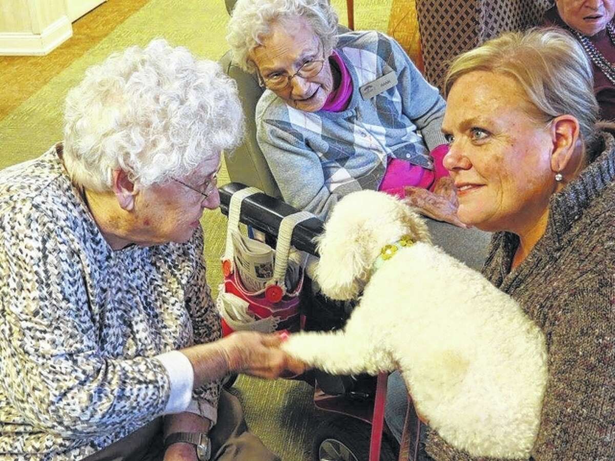 Bark Park volunteer Jan Tiffin holds her dog, Paisley, during a visit Saturday to Knollwood Retirement Village in Jacksonville.