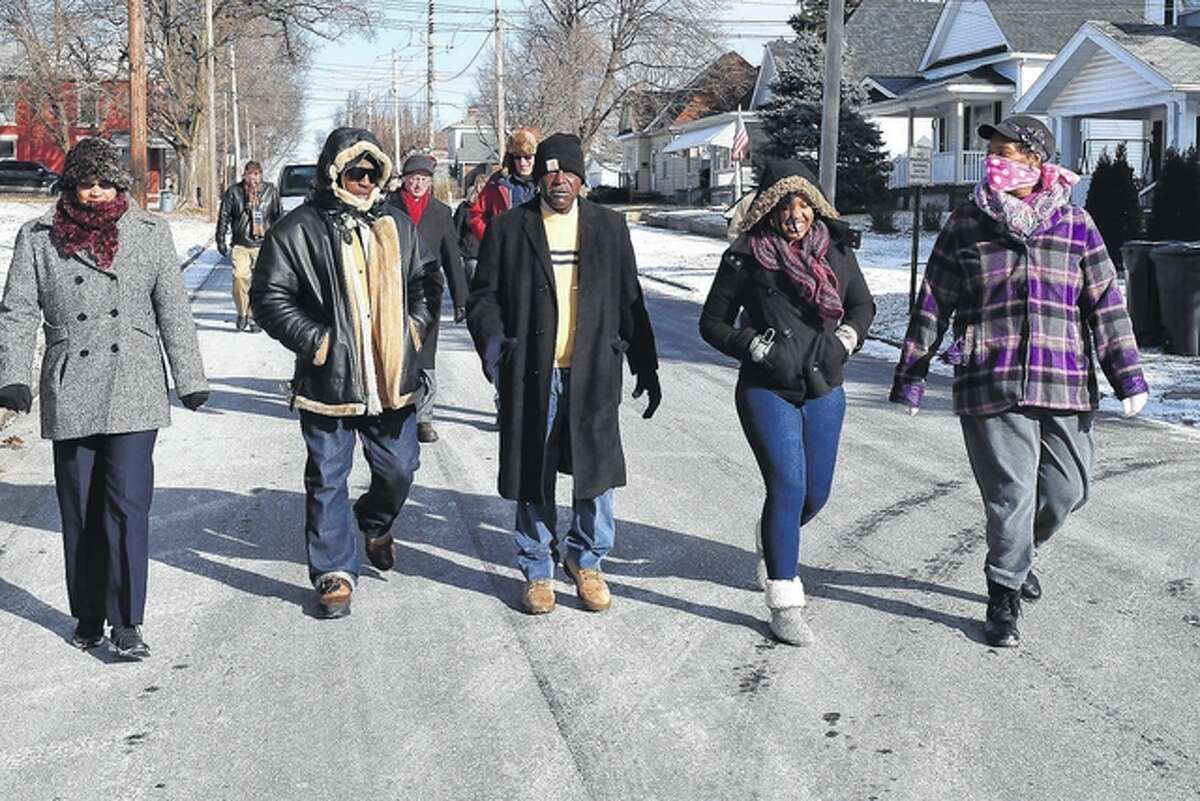 About two dozen people took part Monday in the Dr. Martin Luther King Jr. Day march in Jacksonville. Participants, including King Day organizer Jackie Rogers (center), walked down South Church Street toward the King monument in Community Park.