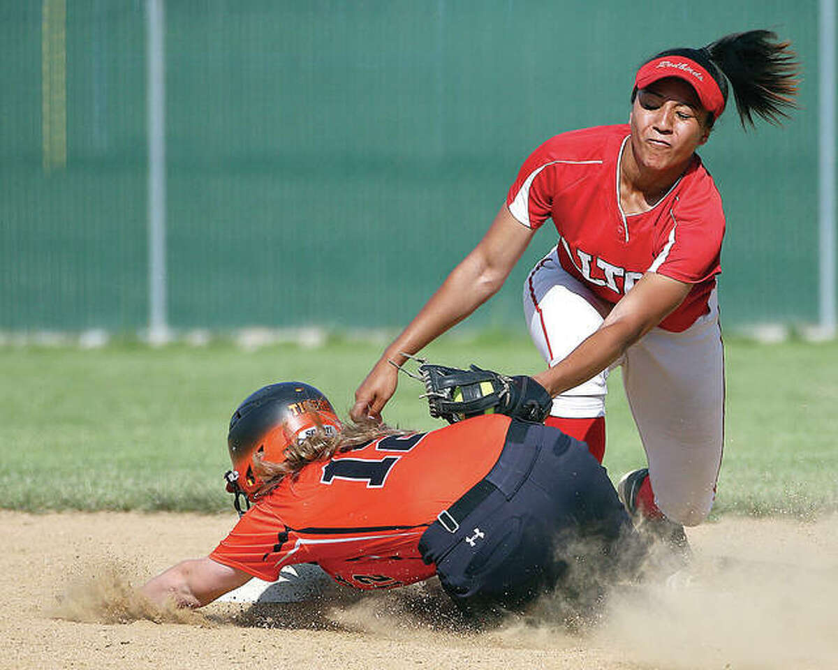 Edwardsville’s Brooke Webber slides into second base, avoiding the tag of Alton’s Savannah Fisher during Thursday’s SWC game at Alton High School.