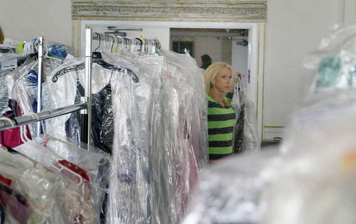 Sarah Hautala, general manager of radio stations WJIL-WJVO, carries an armload of dresses into the ballroom at Hamilton’s in Jacksonville on Saturday in preparation for today’s Bridal and Formal Encore. Gently used wedding and formal clothing has been taken on consignment for the event, including homecoming, prom, wedding and mother-of-the-bride dresses, as well as special-occasion attire such as shoes, jewelry and decor. Doors will open at 11 a.m. today for the event. There is a $1 admission charge, which goes to Prairieland United Way. Hamilton’s is at 110 N. East St.
