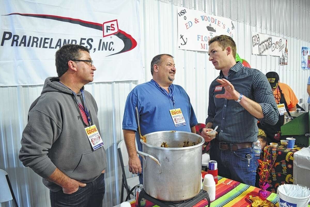 The Prairieland FS chili cook-off team of Ken Devlin of Jacksonville (from left) and Dick Pitchford of Waverly speak with Republican state Senate candidate Bryce Benton of Springfield Saturday at the 19th annual Winchester EMS Chili Cook-off in Winchester.