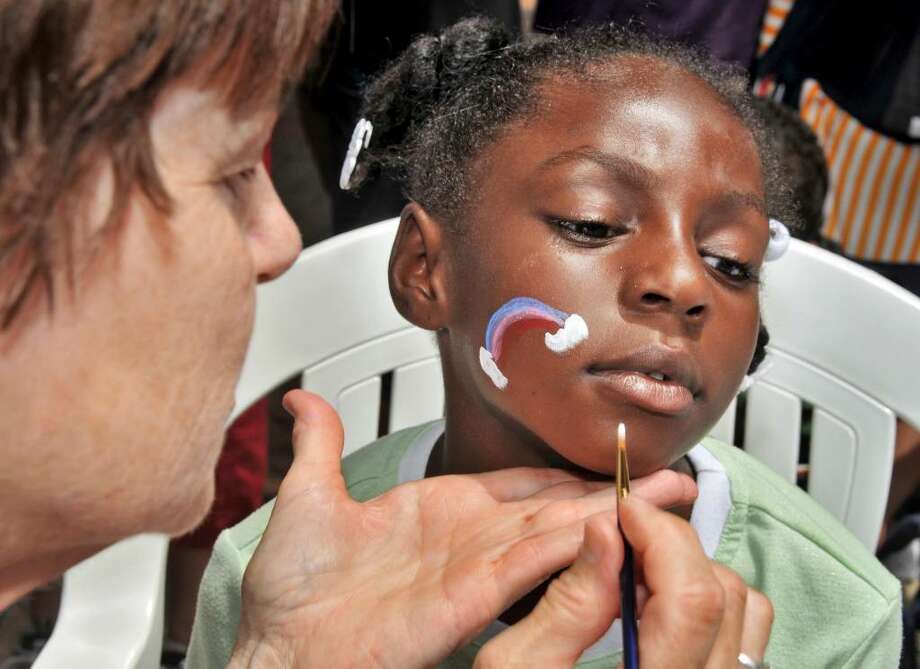 Chris Marotta of Schenectady paints a rainbow on the face of Deasia Bass, 7, of Albany at 16th annual Kids Arts Festival for pre-school and young school age children on the Jay Street pedestrian walkway in Schenectady Saturday afternoon June 5, 2010.  (John Carl D'Annibale / Times Union) Photo: John Carl D'Annibale / 00008979A