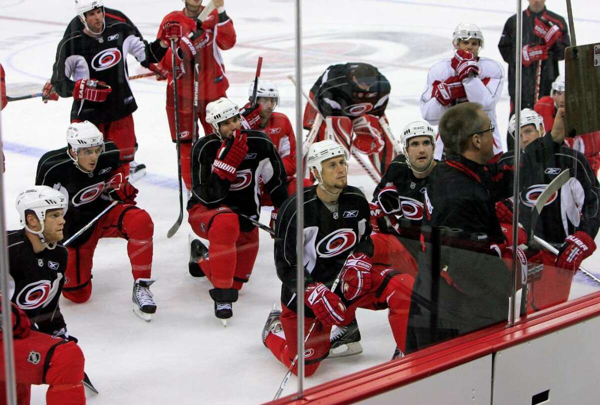 The Hurricanes watches as head coach Paul Maurice diagrams a drill during the practice at the RBC Center in Raleigh, N.C. Defenders are in black sweaters. (Chris Seward/News & Observer)