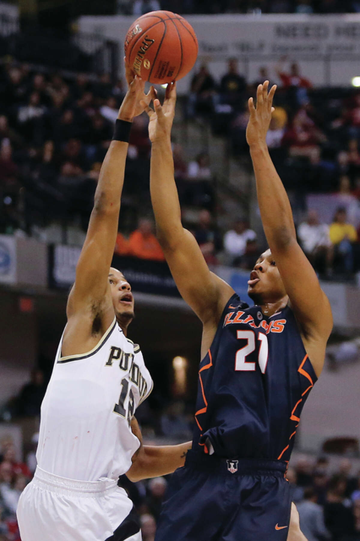 Purdue’s Vince Edwards (left) blocks a shot by Illinois’ Malcolm Hill on Friday in the quarterfinals at the Big Ten Conference tournament in Indianapolis.