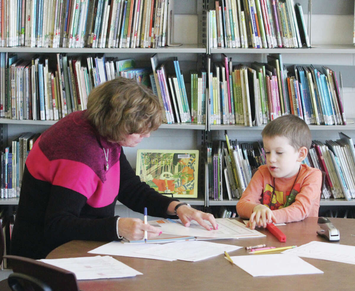 Kindergarten teacher Ruth Miller shows Aaron Maupin what to do during a kindergarten screening at Grafton Elementary School.