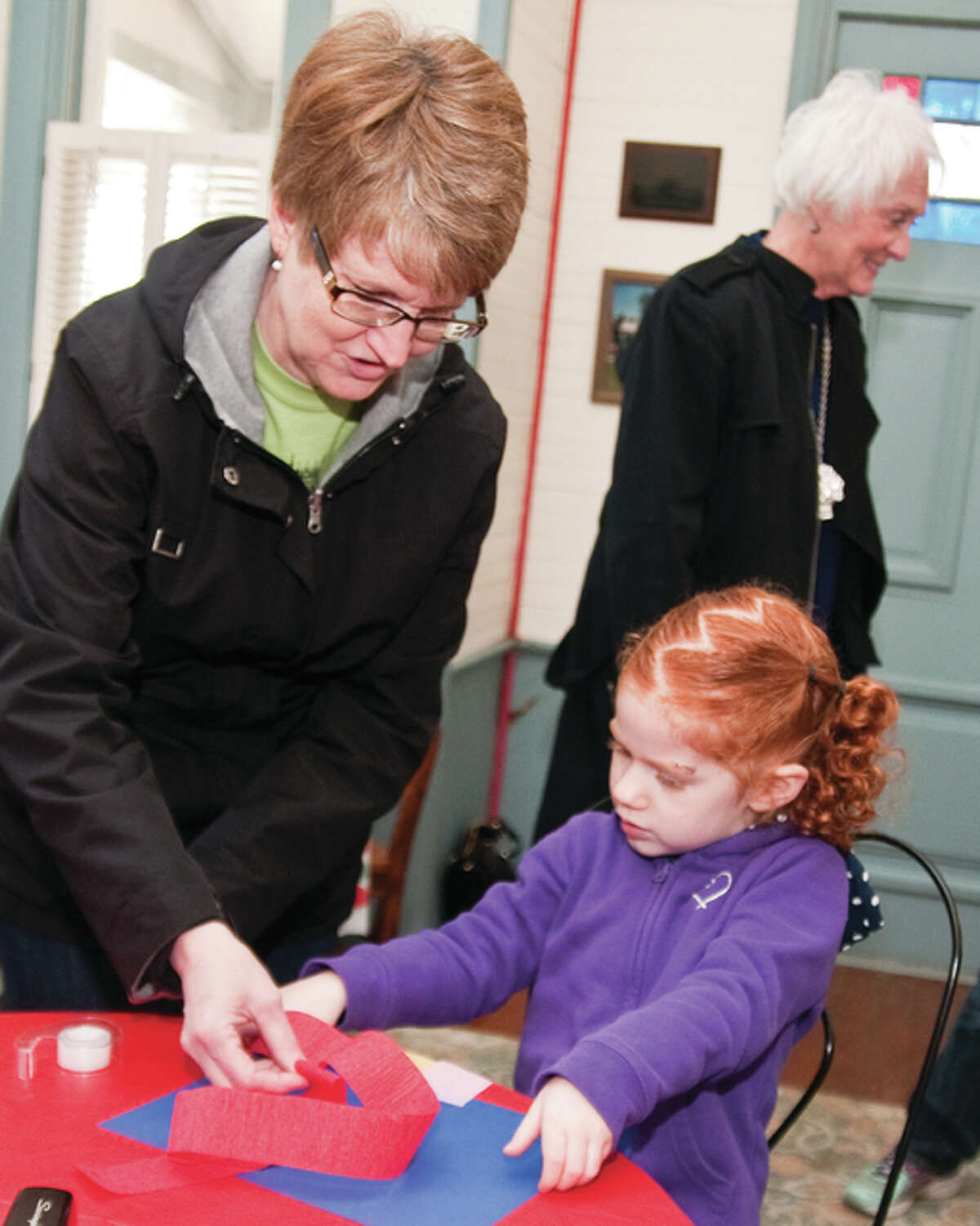 Ann Kuebrich, a member of the Lucy Haskell Playhouse Committee helps 4-year-old Brooke Pals put together a wind sock on Saturday morning inside the Playhouse. Pals and her younger sister Ryleigh came to the playhouse with her grandmother Lynn Sansone all the way from Warren County, Missouri. Sansone said she saw this event listed on Facebook and thought her granddaughters would like taking part in this event.