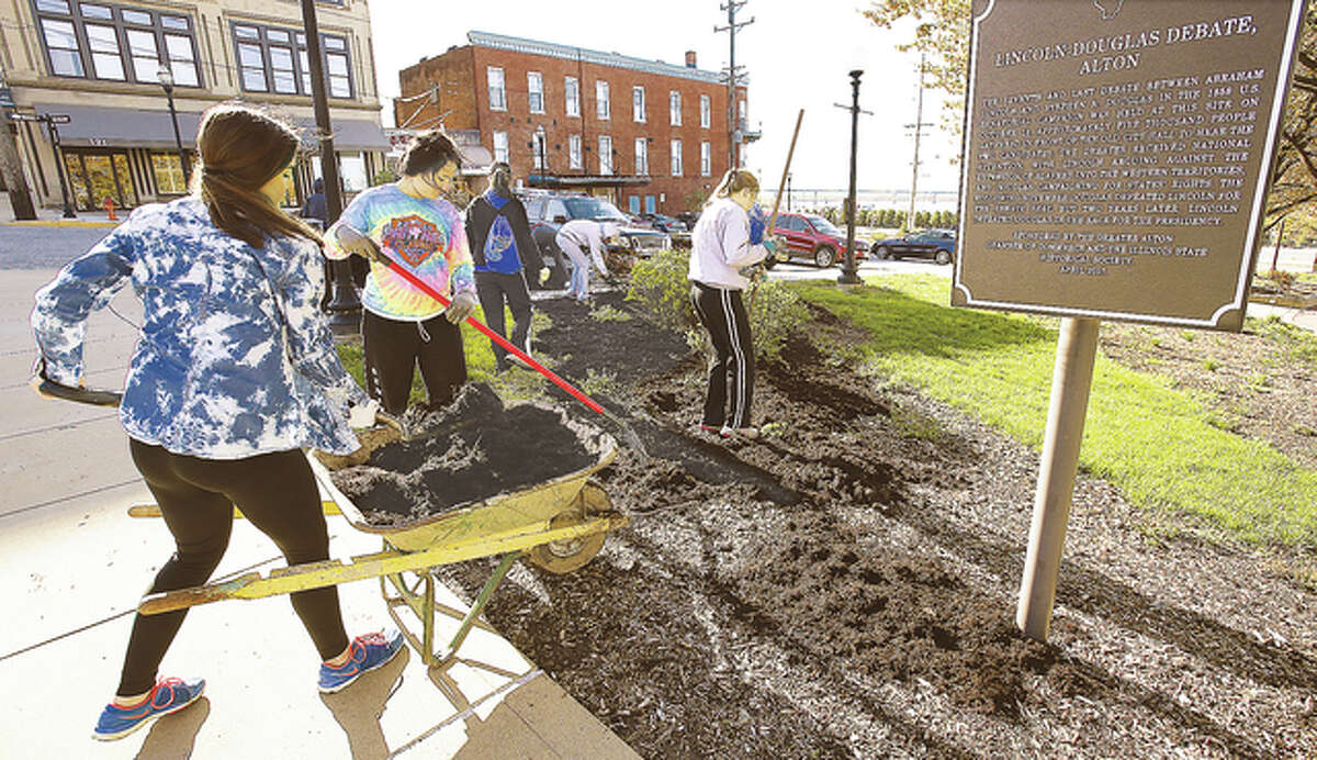 A large group of students were spreading much-needed mulch around Downtown Alton’s parking islands, like here, at Lincoln-Douglas Square.