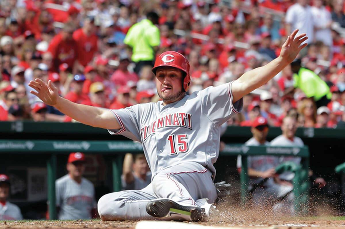 The Reds’ Jordan Pacheco slides safely across the plate during the sixth inning of Cincinnati’s win over the Cardinals on Saturday at Busch Stadium.