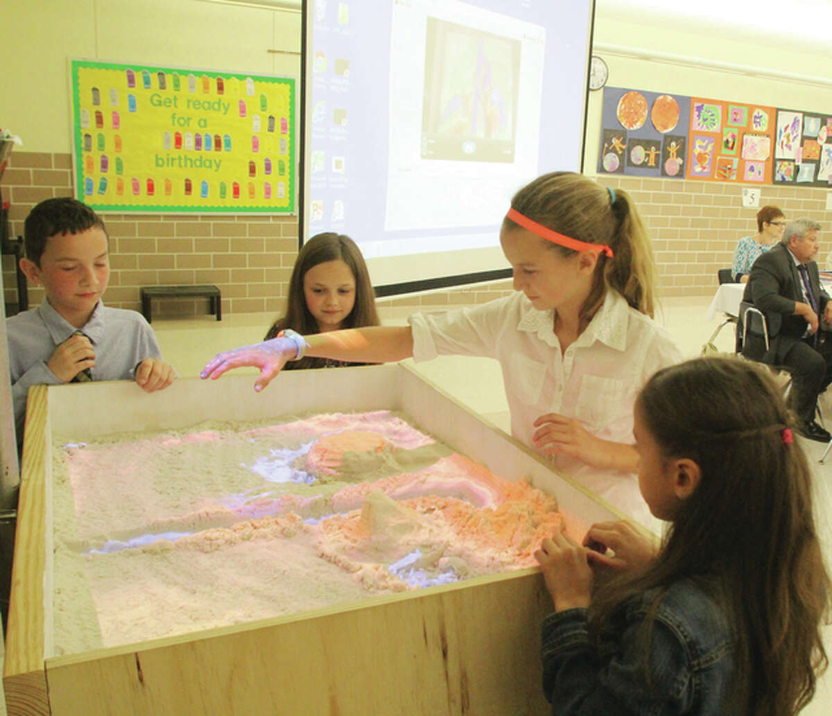 Students demonstrate the “Augmented Reality Sandbox” at Monday’s Edwardsville school board meeting. The sandbox uses technology to allow students to learn about social studies and science.