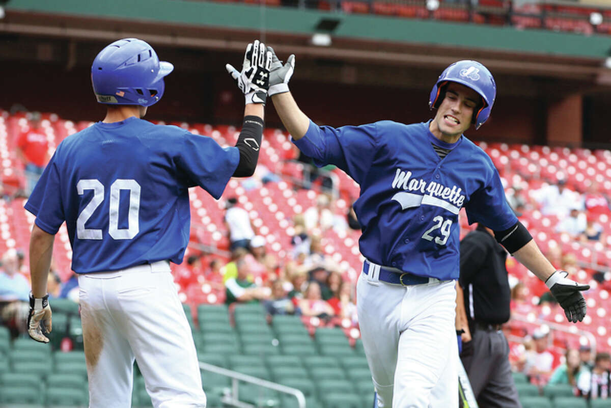 Marquette Catholic’s John Blachford (right) and Jayce Maag (20) celebrate after scoring a run during Sunday’s prep baseball game against the Salem Wildcats following the Cardinals loss to the Nationals at Busch Stadium. The Explorers beat the Wildcats 8-7 to improve their record to 10-11. Marquette is back at home on Monday, taking on Belleville Althoff at Hopkins Field in Alton.