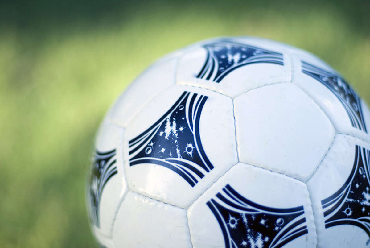 a white and black soccer ball with a green grass background
