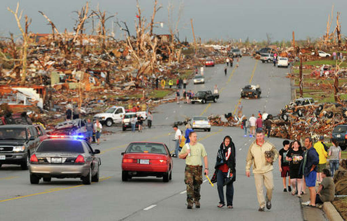 In this May 22, 2011, file photo residents walk in the street after a massive tornado hit Joplin, Mo. A sky-darkening storm was working its way into southwest Missouri around dinnertime on a Sunday evening of May 22, 2011, zeroing in on the city of Joplin. As storm sirens blared, one of the nation’s deadliest tornados hit, leveling a miles-wide swath of Joplin and leaving 161 people dead.