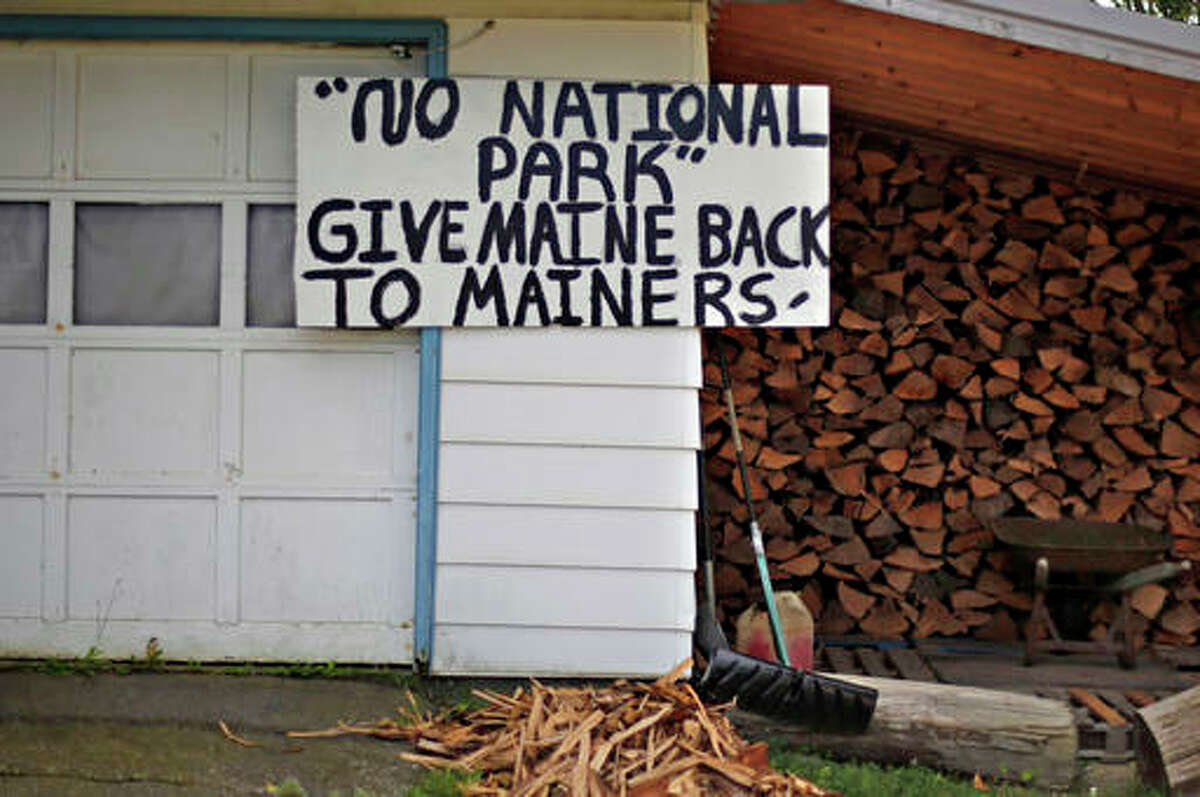 In this Sunday, Aug. 9, 2015, file photo, a sign in opposition to a proposed national park is seen on a home in Millinocket, Maine. The former Great Northern Paper Co. mill closed in February 2013, devastating the Katahdin region economy. A congressional field hearing this week on a proposal to create a national monument shows how the lines have been drawn.