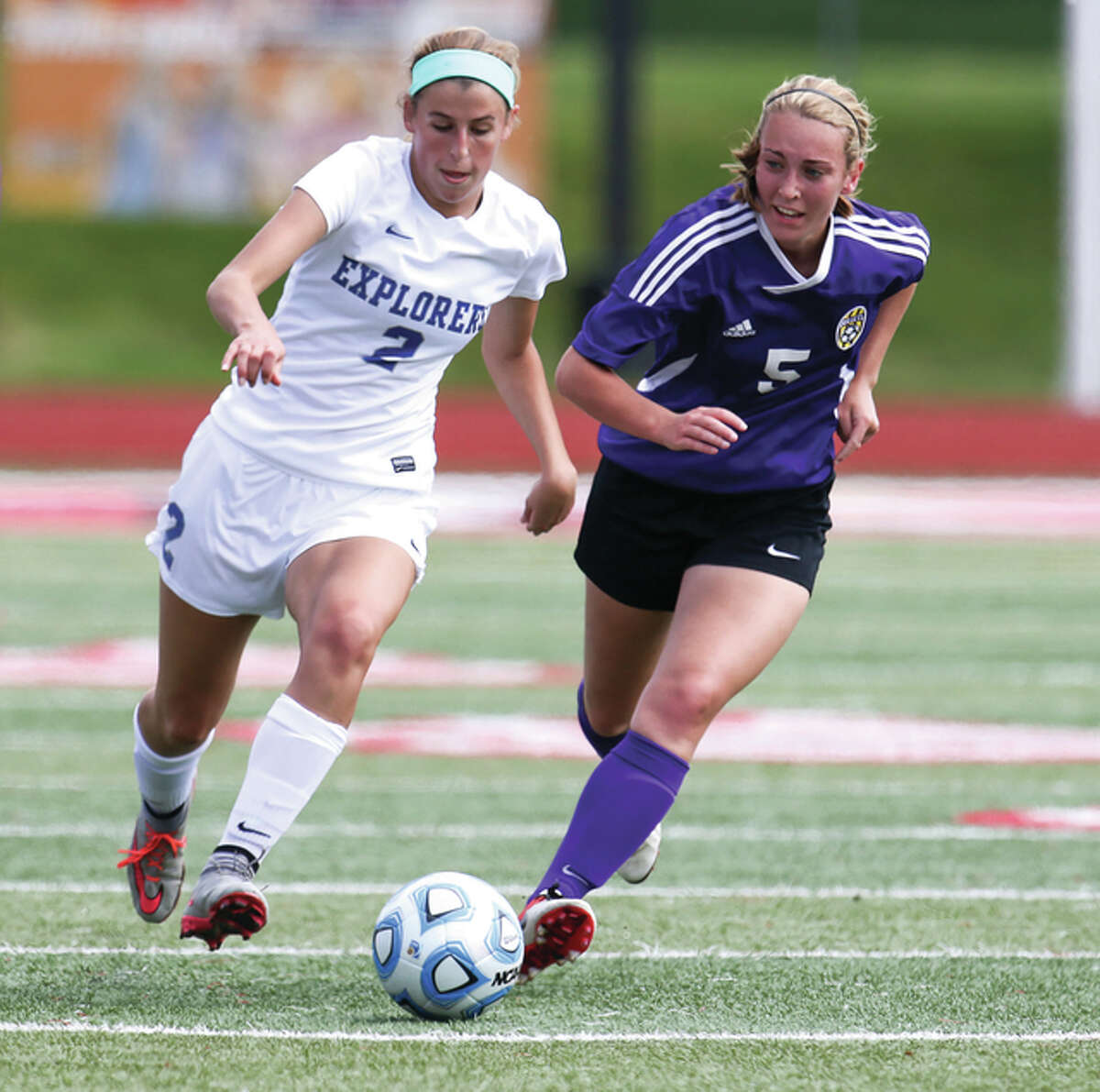 Marquette Catholic’s Annabelle Copeland (left) moves the ball up the pitch against Williamsville’s Annie Gantt during the Class 1A state girls soccer third-place game Saturday at North Central College in Naperville.