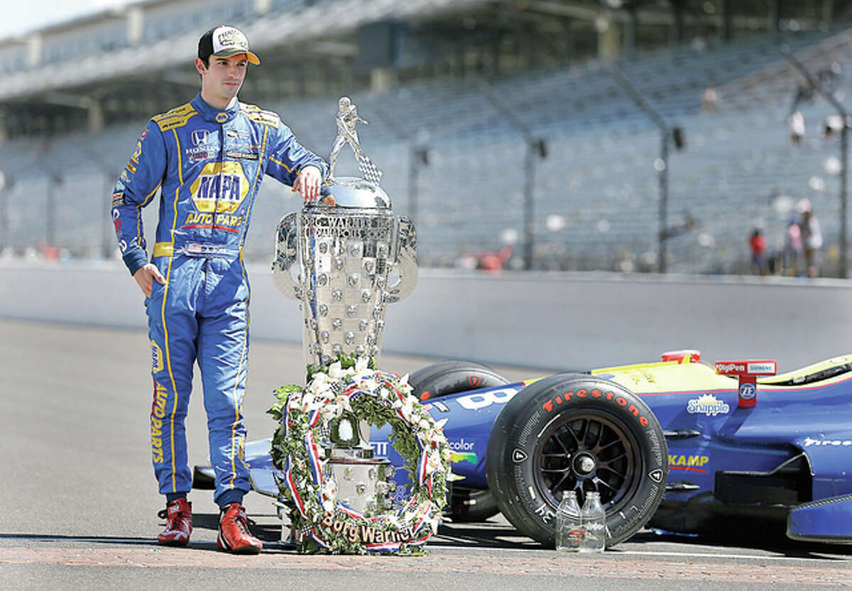 Indianapolis 500 champion Alexander Rossi poses with the Borg-Warner Trophy during the traditional winners photo on the start/finish line Monday at Indianapolis Motor Speedway.