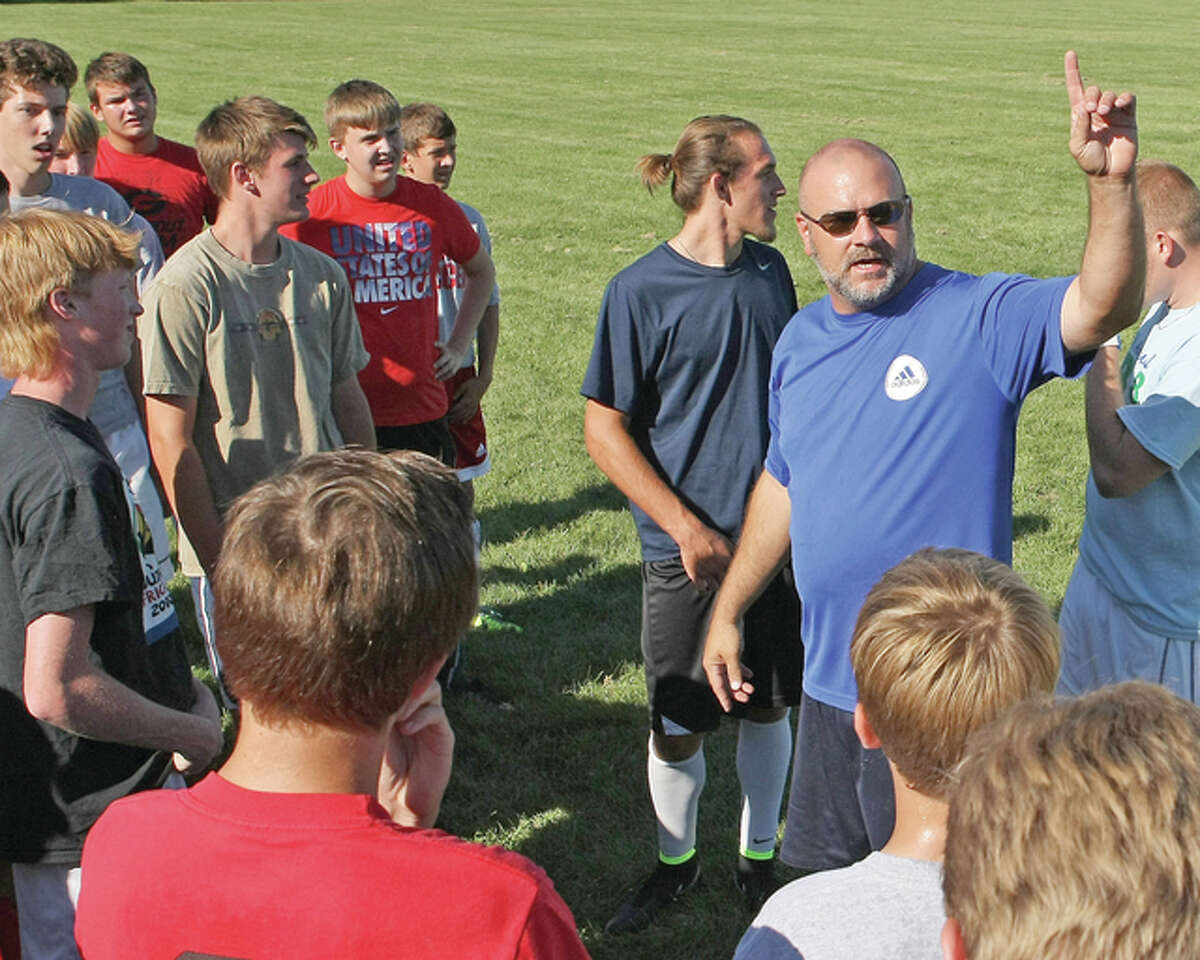 Former Alton boys soccer coach, Jay Robertson speaks with his players prior to a practice in preparation for the 2014 season. Robertson has resigned as boys soccer coach at AHS after six seasons.