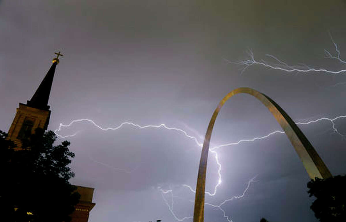 Lightning flashes in the sky behind the Gateway Arch, right, and Old Cathedral, left, as a line of thunderstorms moves through St. Louis, Wednesday, May 11, 2016. Thousands of Ameren Corp. customers in the St. Louis area are without power after the strong thunderstorm hit the region. (AP Photo/Jeff Roberson)