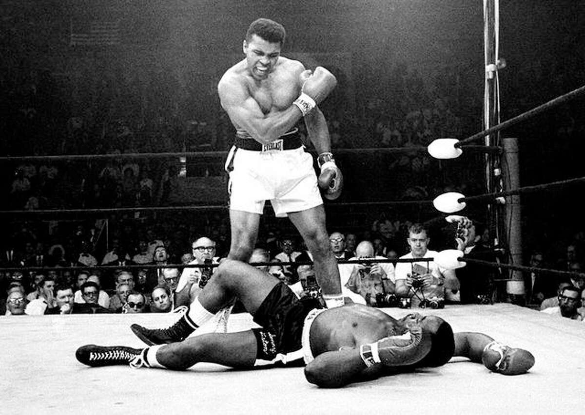 Heavyweight champion Muhammad Ali, then known as Cassius Clay, stands over challenger Sonny Liston, shouting and gesturing shortly after dropping Liston with a short hard right to the jaw, in Lewiston, Me. in this May 25, 1965 file photo. Ali was declared the winner. The bout lasted only one minute into the first round.