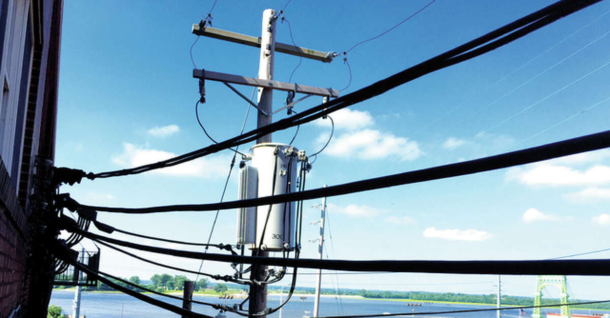 Electric lines stretch toward the Mississippi River in Alton on a sunny day. Consumers should consider several things before switching electric suppliers, who often sell their services door-to-door and over the phone.