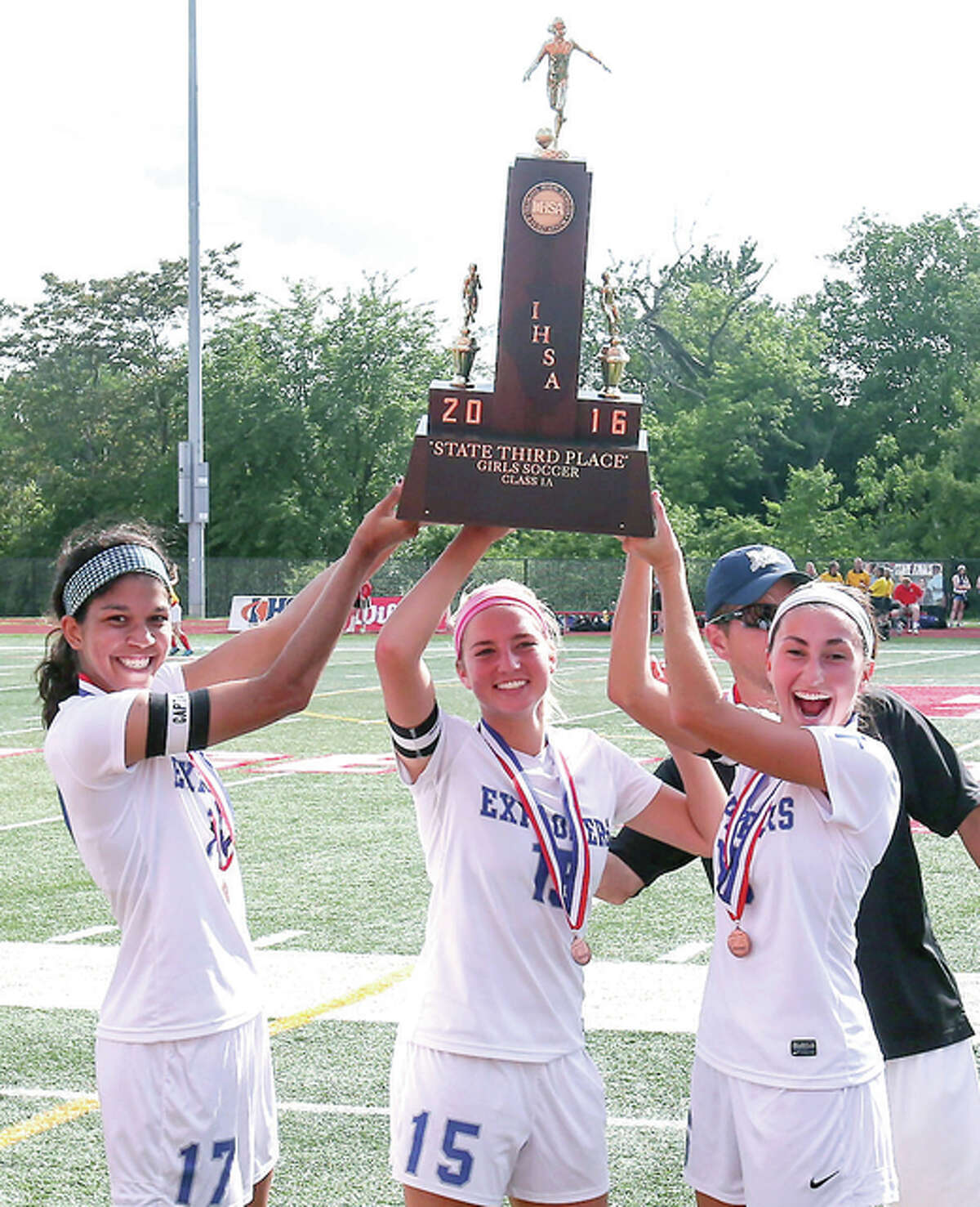 Marquette Catholic captains, from left, Adrianna Schindler, Bailey Hartrich and forward Lauren Schmickley hold up the Class 1A third-place trophy after beating Williamsville at North Central College.
