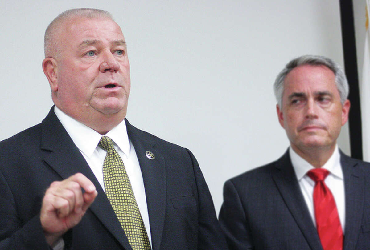Madison County Sheriff John Lakin, left, and State’s Attorney Tom Gibbons, right, speak to members of the media at a conference Thursday afternoon about Keaun Cook, an 18-year-old Godfrey man who was charged with two counts of terrorism.