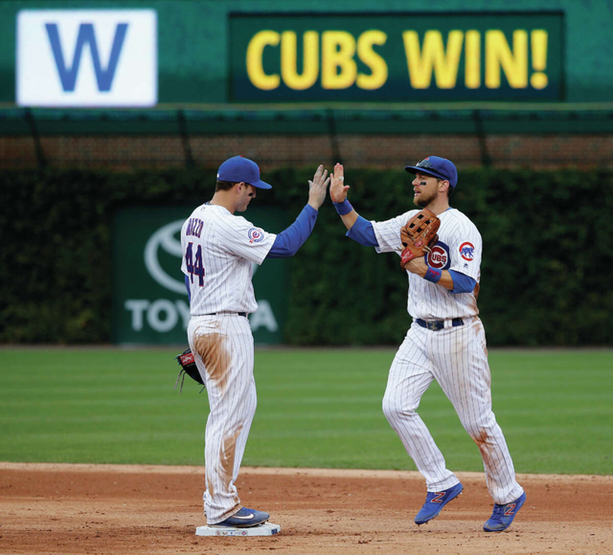 The Cubs’ Anthony Rizzo (left) and Ben Zobrist celebrate the Cubs’ 5-0 shutout of the St. Louis Cardinals on Friday at Wrigley Field in Chicago.