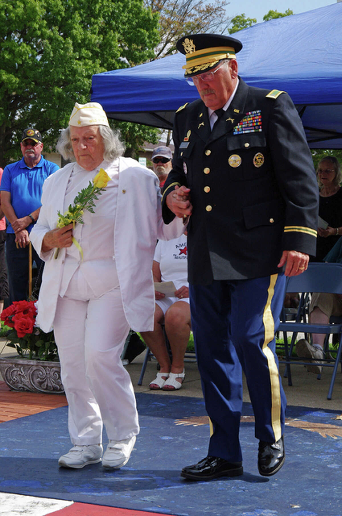 Gold Star mother Deloris Molloy walks toward the War Memorial to place a rose during Sunday’s Gold Star Mothers Ceremony in Jerseyville. Escorting her is retired U.S. Army Chief Warrant Officer 4 Terry Day.