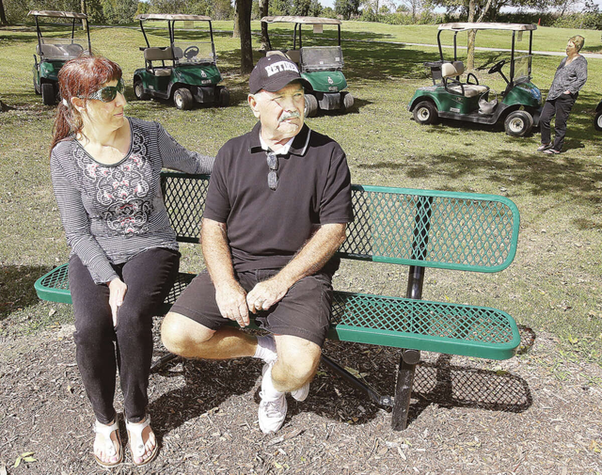 Dianne Gordon, left, widow of David L. Gordon, who died unexpectedly, and Jerry Gordon, right, David’s brother, sit on the bench dedicated Wednesday and placed near the 5th hole at the Rolling Hills Golf Course in Godfrey. David Gordon was an avid golfer.