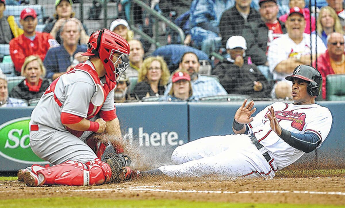 Cardinals catcher Ed Easley (left) tags out the Braves’ Hector Olivera at home plate on a fielder’s choice during the fourth inning of the second game of Sunday’s doubleheader in Atlanta.