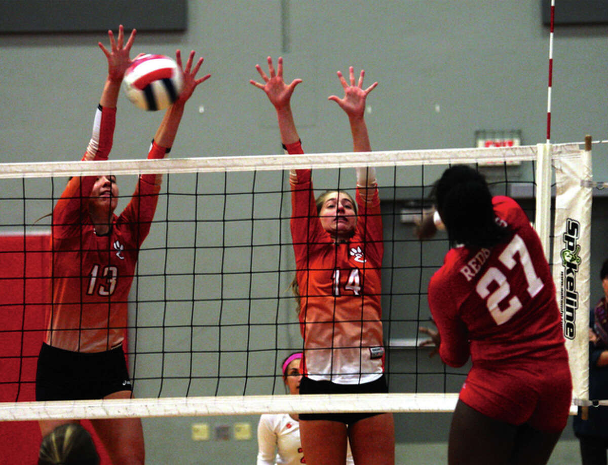 Edwardsville’s 6-2 middle Annie Ellis (left) blocks an attack from Alton’s Jada Green (27) while the Tigers Kate Martin also puts up a block during the Tigers’ two-set Southwestern Conference volleyball victory Thursday night at Alton High in Godfrey.