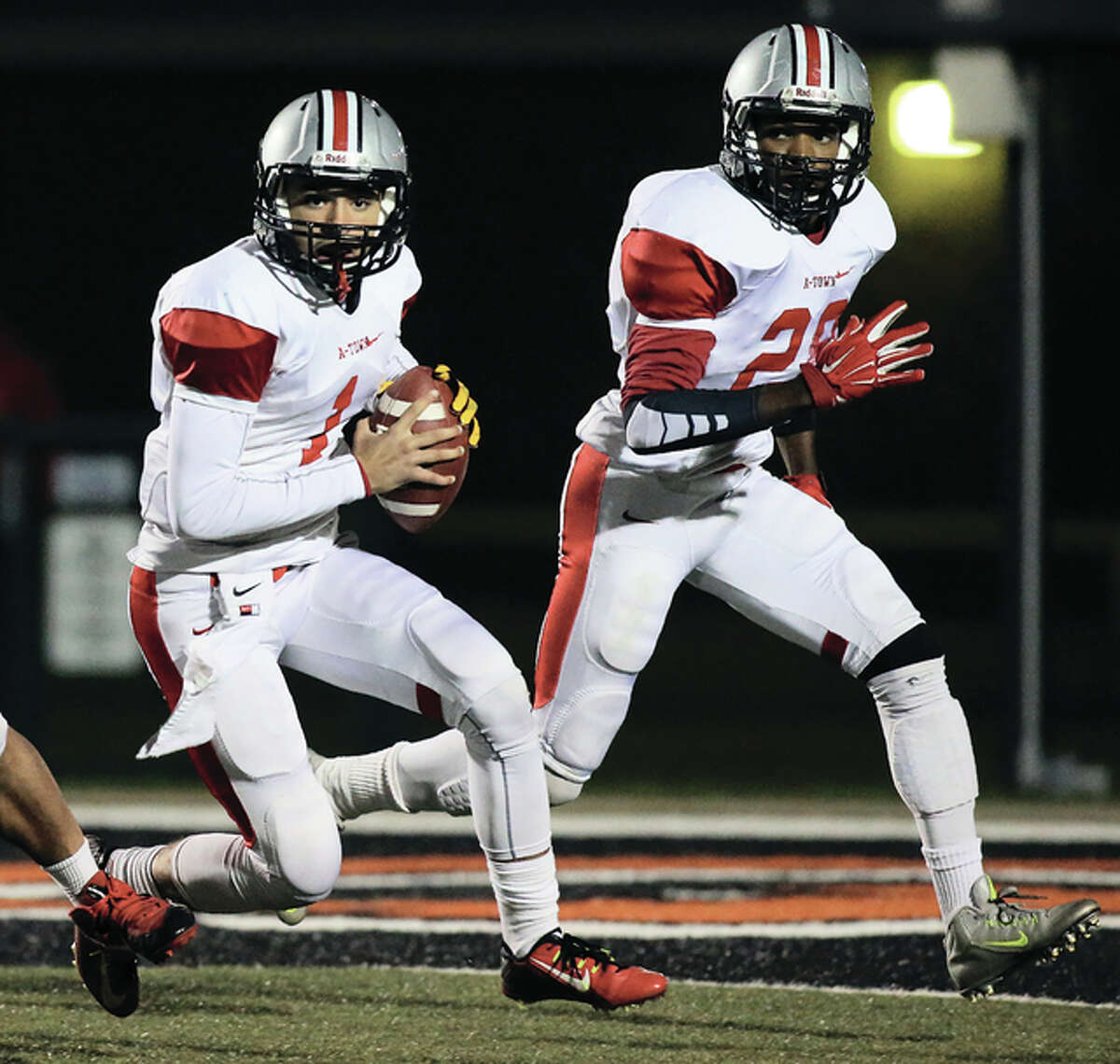Alton quarterback Keenan Stegall (left) looks for room to run while running back Asa Collins follows the play as a pitch option during last Friday’s Southwestern Conference football game at the District 7 Sports Complex in Edwardsville.