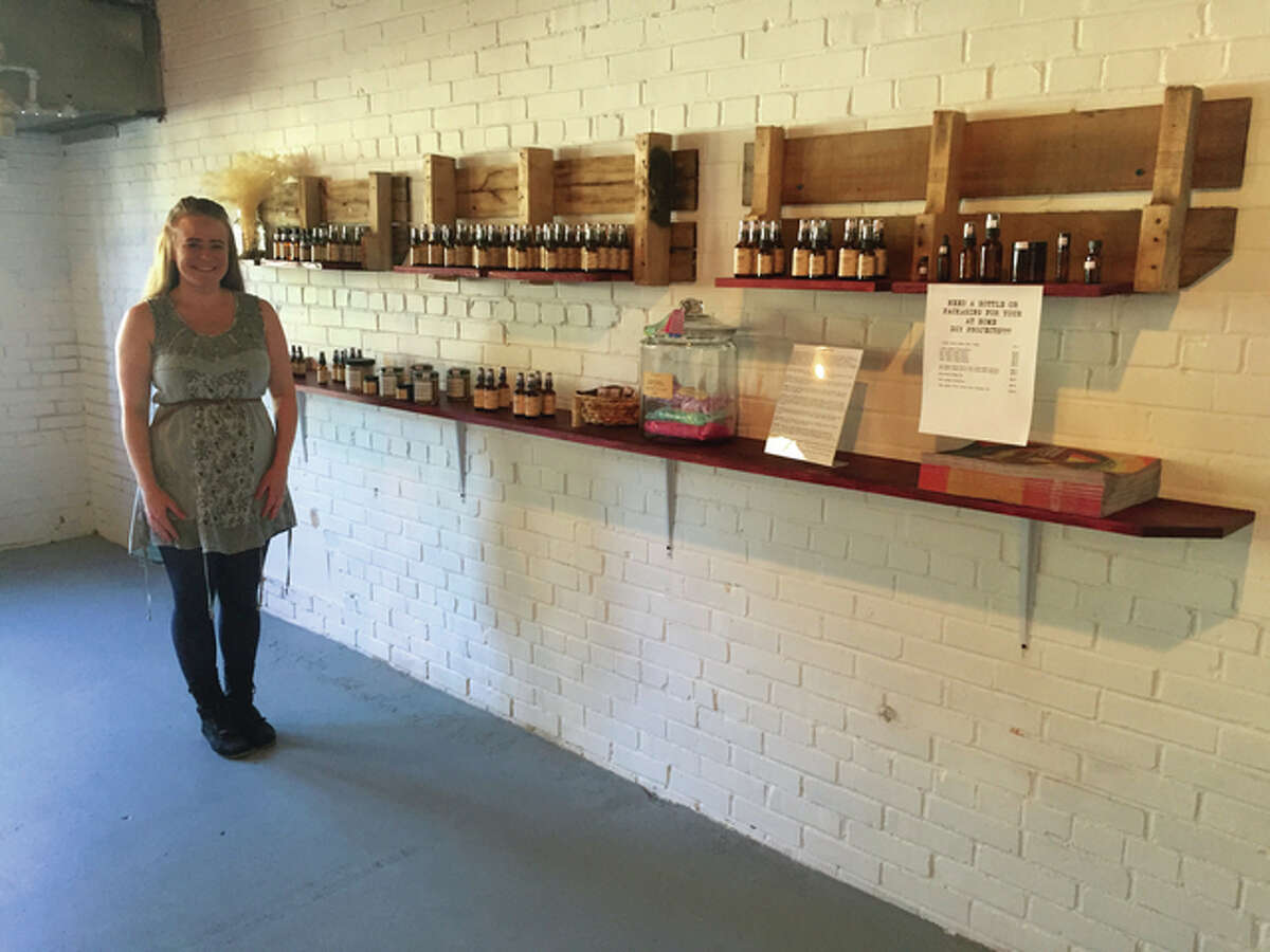 Orb Elements owner Lora Ruppert-Aulabaugh poses in the retail section of her aromatherapy shop in the old Milton Schoolhouse.