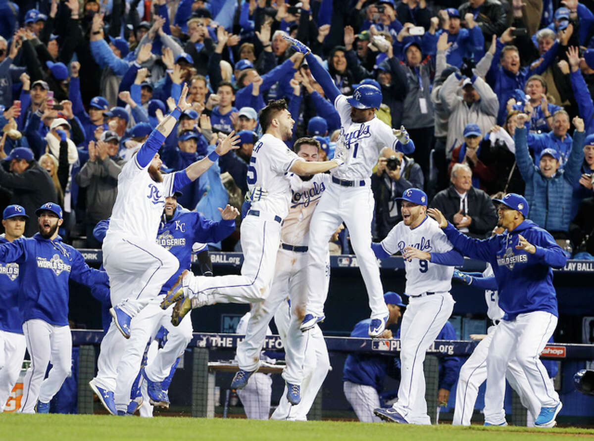 Royals players celebrate after Alcides Escobar scored on a sacrifice fly by Eric Hosmerth ending Game 1 of the World Series against the Mets in the 14th inning Wednesday in Kansas City. The Royals won 5-4.