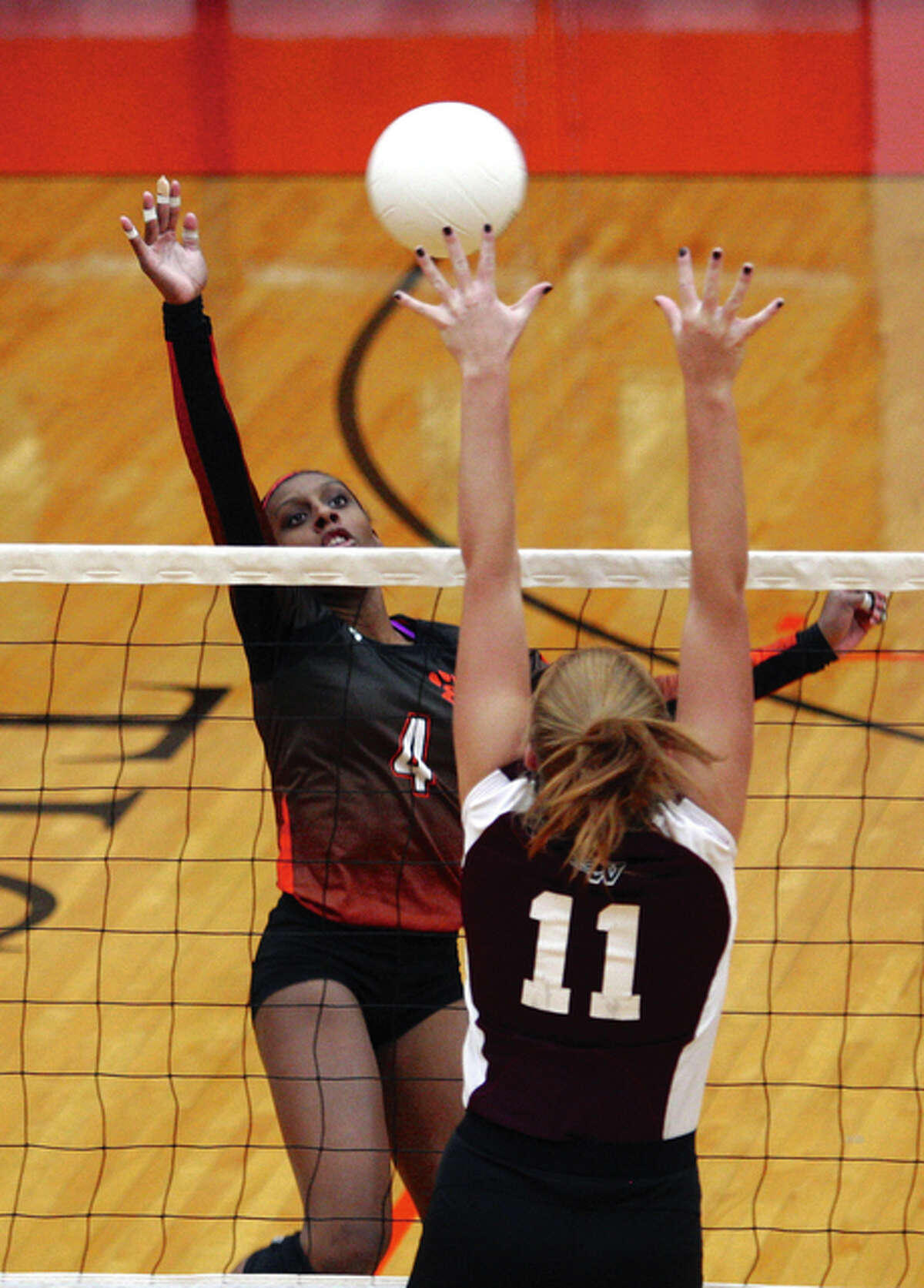 Edwardsville senior Sydney Wright (left) hits past the block of Belleville West’s Nicole Braner during West’s three-set SWC victory Oct. 20 in Edwardsville. Both teams play for Class 4A regional titles Thursday, with the Tigers meeting O’Fallon in Granite City and the Maroons taking on Breese Mater Dei at Belleville West.