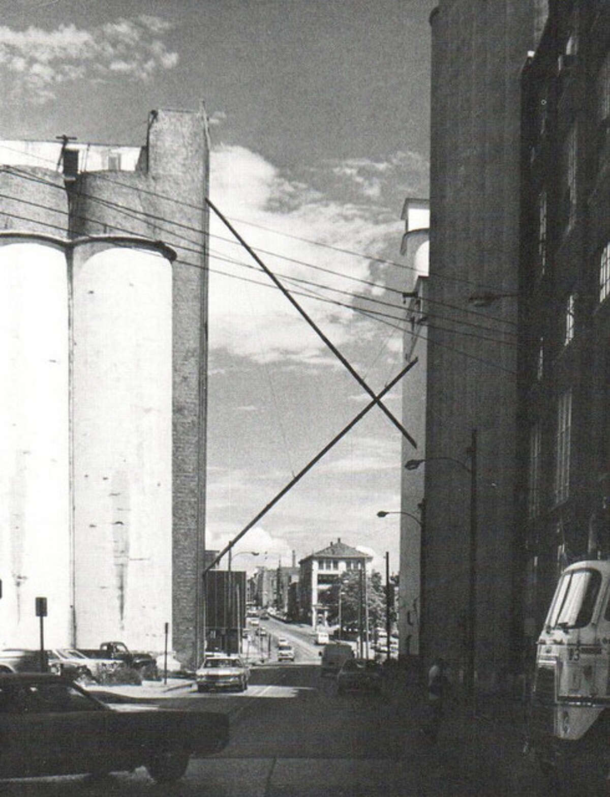 A scene at the intersection of West Broadway and State Streets shows the entire block of grain storage silos and milling complex. Prior to that time, State Street ended at the river. It was not unusual for a southbound car’s brakes to fail on State Street hill, quickly depositing the unfortunate car and driver into the Mississippi.