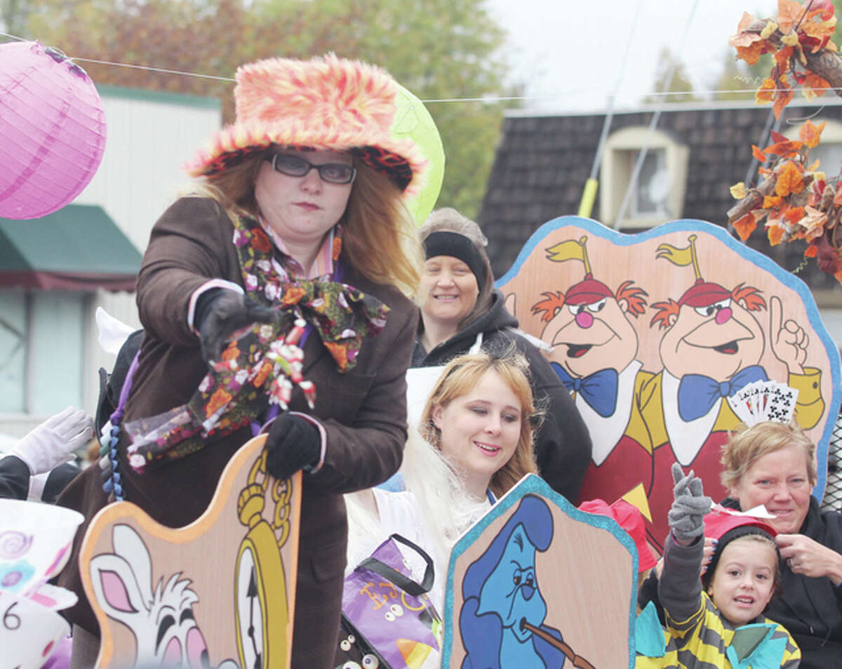 A Mad Hatter throws candy from an “Alice In Wonderland” themed float by the East Alton Women’s Club at the annual Wood River Halloween Parade Saturday morning.